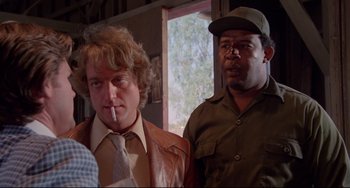 Movie still from “Used Cars” (1980), directed by Robert Zemeckis – Two men standing next to each other in front of a window; Close Up shot, Over the shoulder angle