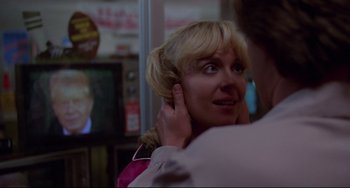 Movie still from “Used Cars” (1980), directed by Robert Zemeckis – A woman is holding her face up to her ear; Close Up shot, Over the shoulder angle
