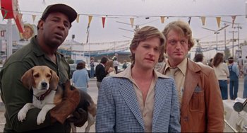 Movie still from “Used Cars” (1980), directed by Robert Zemeckis – A group of men standing next to each other on a street; Medium shot, Low angle