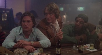 Movie still from “Used Cars” (1980), directed by Robert Zemeckis – A group of men sitting at a table drinking beer; Medium shot, Low angle