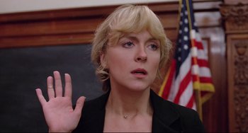 Movie still from “Used Cars” (1980), directed by Robert Zemeckis – A woman with blonde hair waves her hand in front of an american flag; Close Up shot, Low angle