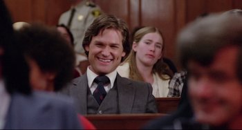 Movie still from “Used Cars” (1980), directed by Robert Zemeckis – A man in a suit and tie sitting next to a woman; Medium shot, Over the shoulder angle