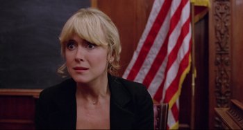 Movie still from “Used Cars” (1980), directed by Robert Zemeckis – A woman sitting in front of an american flag; Close Up shot, Over the shoulder angle