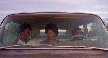 Movie still from “Used Cars” (1980), directed by Robert Zemeckis – Three young men in the back seat of a car; Medium shot, Low angle