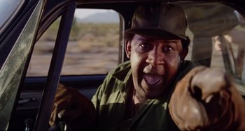 Movie still from “Used Cars” (1980), directed by Robert Zemeckis – A man in a hat driving in a car; Close Up shot, Low angle