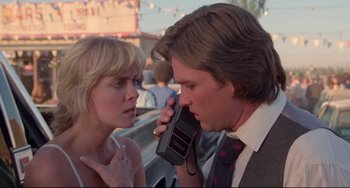 Movie still from “Used Cars” (1980), directed by Robert Zemeckis – A man and a woman talking on a cell phone; Close Up shot, Low angle