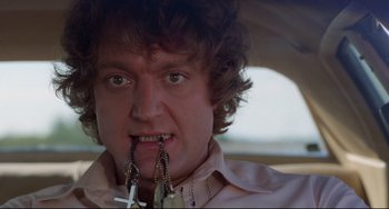 Movie still from “Used Cars” (1980), directed by Robert Zemeckis – A man with a bunch of keys in his mouth; Close Up shot, Low angle