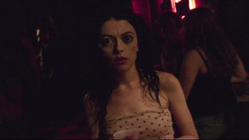 Movie still from “V/H/S” (2012), directed by Joe Swanberg – A woman in a polka dot dress holding a drink; Close Up shot, Over the shoulder angle