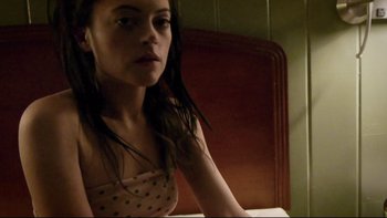 Movie still from “V/H/S” (2012), directed by Joe Swanberg – A woman sitting on a bed looking at the camera; Close Up shot, High angle