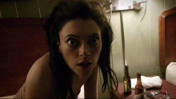 Movie still from “V/H/S” (2012), directed by Joe Swanberg – A woman with dreadlocks is looking at the camera; Close Up shot, Overhead angle