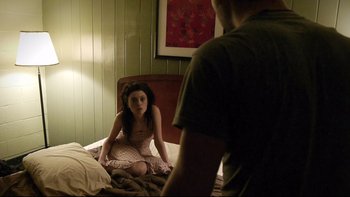 Movie still from “V/H/S” (2012), directed by Joe Swanberg – A woman sitting on a bed next to a man; Medium shot, Over the shoulder angle