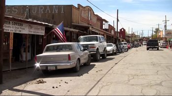 Movie still from “V/H/S” (2012), directed by Joe Swanberg – A row of cars parked on the side of the street; Wide shot, High angle