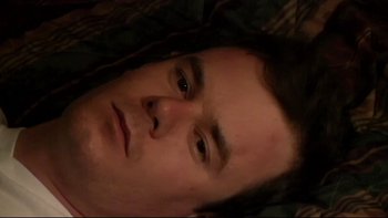 Movie still from “V/H/S” (2012), directed by Joe Swanberg – A man's face as he lays on a bed; Close Up shot, Overhead angle