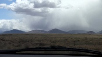 Movie still from “V/H/S” (2012), directed by Joe Swanberg – A view from a car of a field with mountains in the background; Extreme Wide shot, Low angle