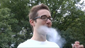 Movie still from “V/H/S” (2012), directed by Joe Swanberg – A man with glasses is smoking a cigarette; Close Up shot, Low angle