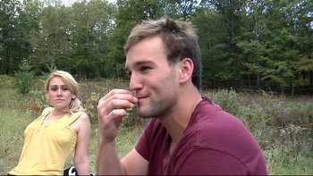 Movie still from “V/H/S” (2012), directed by Joe Swanberg – A man eating a sandwich while sitting next to a woman; Close Up shot, Over the shoulder angle