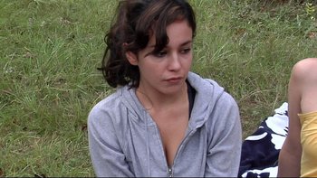 Movie still from “V/H/S” (2012), directed by Joe Swanberg – A woman sitting in the grass looking sad; Close Up shot, High angle