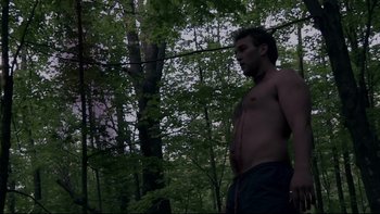 Movie still from “V/H/S” (2012), directed by Joe Swanberg – A man standing in the middle of a forest; Medium shot, Low angle