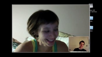 Movie still from “V/H/S” (2012), directed by Joe Swanberg – A woman smiles as she talks to a man on a video call; Medium shot, Over the shoulder angle