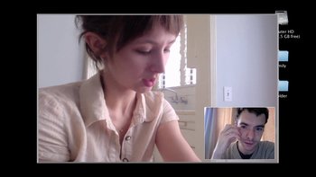 Movie still from “V/H/S” (2012), directed by Joe Swanberg – A young woman sitting in front of a man on a phone; Close Up shot, High angle