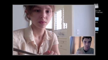 Movie still from “V/H/S” (2012), directed by Joe Swanberg – A young woman is sitting in front of a window; Close Up shot, Over the shoulder angle