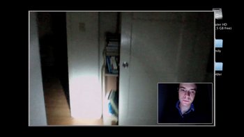 Movie still from “V/H/S” (2012), directed by Joe Swanberg – A man in a dark room with a light shining on him; Extreme Wide shot, High angle