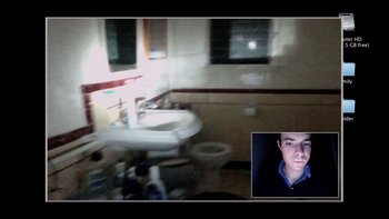 Movie still from “V/H/S” (2012), directed by Joe Swanberg – A man is in a bathroom with a sink and toilet; Extreme Wide shot, High angle