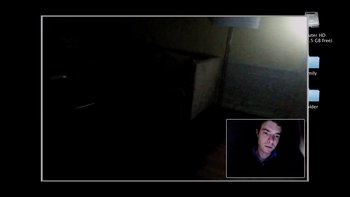 Movie still from “V/H/S” (2012), directed by Joe Swanberg – A man in a dark room looking at the camera; Wide shot, Overhead angle