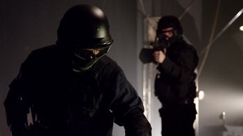 Movie still from “V/H/S Viral” (2014), directed by Aaron Moorhead – Two men in black suits and helmets are holding guns; Medium shot, Low angle
