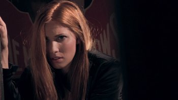 Movie still from “V/H/S Viral” (2014), directed by Aaron Moorhead – A beautiful young lady with long red hair and wearing a black jacket; Close Up shot, Over the shoulder angle