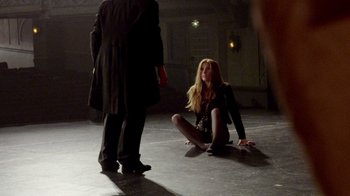 Movie still from “V/H/S Viral” (2014), directed by Aaron Moorhead – A woman sitting on the ground next to a man in a suit; Wide shot, High angle