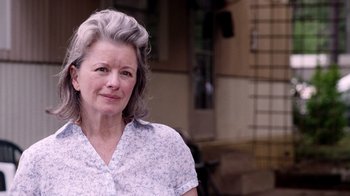 Movie still from “V/H/S Viral” (2014), directed by Aaron Moorhead – An older woman with gray hair is posing for a picture; Close Up shot, Over the shoulder angle