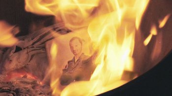 Movie still from “V/H/S Viral” (2014), directed by Aaron Moorhead – A man sitting in front of a fire; Extreme Close Up shot, High angle