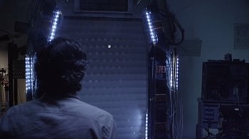 Movie still from “V/H/S Viral” (2014), directed by Aaron Moorhead – A man standing in front of an escalator at night; Medium shot, Low angle
