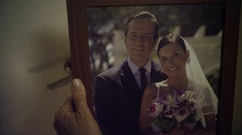 Movie still from “V/H/S Viral” (2014), directed by Aaron Moorhead – A man and a woman holding up a picture of them; Extreme Close Up shot, Over the shoulder angle