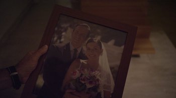 Movie still from “V/H/S Viral” (2014), directed by Aaron Moorhead – A man holding a picture of a bride and groom; Extreme Close Up shot, Over the shoulder angle