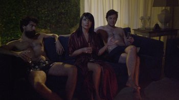 Movie still from “V/H/S Viral” (2014), directed by Aaron Moorhead – A woman sitting on a couch next to two men; Medium shot, High angle