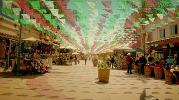 Movie still from “V/H/S Viral” (2014), directed by Aaron Moorhead – A market area with a lot of green and pink flags hanging from the ceiling; Extreme Wide shot, High angle
