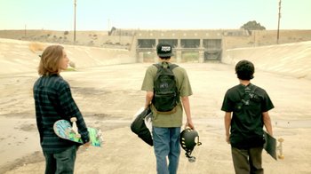 Movie still from “V/H/S Viral” (2014), directed by Aaron Moorhead – Three skateboarders are walking down a dirt road; Wide shot, Low angle