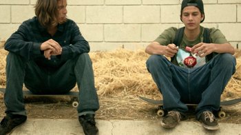 Movie still from “V/H/S Viral” (2014), directed by Aaron Moorhead – Two young men sitting next to each other on skatebaords; Medium shot, Low angle