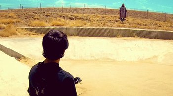 Movie still from “V/H/S Viral” (2014), directed by Aaron Moorhead – A man standing in the middle of an empty field; Wide shot, Over the shoulder angle