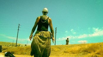 Movie still from “V/H/S Viral” (2014), directed by Aaron Moorhead – A person wearing a helmet and a mask on their head; Wide shot, Low angle