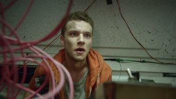 Movie still from “V/H/S Viral” (2014), directed by Aaron Moorhead – A man in an orange jacket looking at the camera; Close Up shot, Low angle