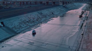 Movie still from “V/H/S Viral” (2014), directed by Aaron Moorhead – A person riding a bike on top of an ice covered road; Extreme Wide shot, High angle