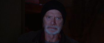 Movie still from “VFW” (2019), directed by Joe Begos – An old man with a beard and a black hat; Close Up shot, Over the shoulder angle