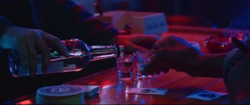 Movie still from “VFW” (2019), directed by Joe Begos – A bottle of alcohol is being poured into a shot glass; Close Up shot, Low angle