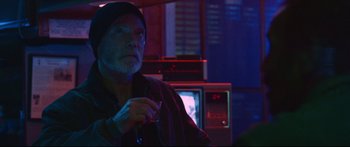 Movie still from “VFW” (2019), directed by Joe Begos – An older man sitting in front of a television set; Medium shot, Low angle