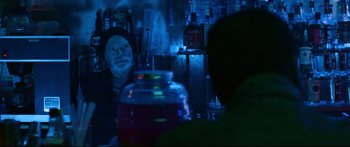 Movie still from “VFW” (2019), directed by Joe Begos – A man sitting at a table in a dark room; Medium shot, Over the shoulder angle