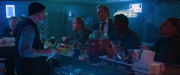 Movie still from “VFW” (2019), directed by Joe Begos – A group of people sitting at a bar; Medium shot, Over the shoulder angle