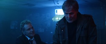 Movie still from “VFW” (2019), directed by Joe Begos – A man and a woman are standing in a dark room; Medium shot, Over the shoulder angle